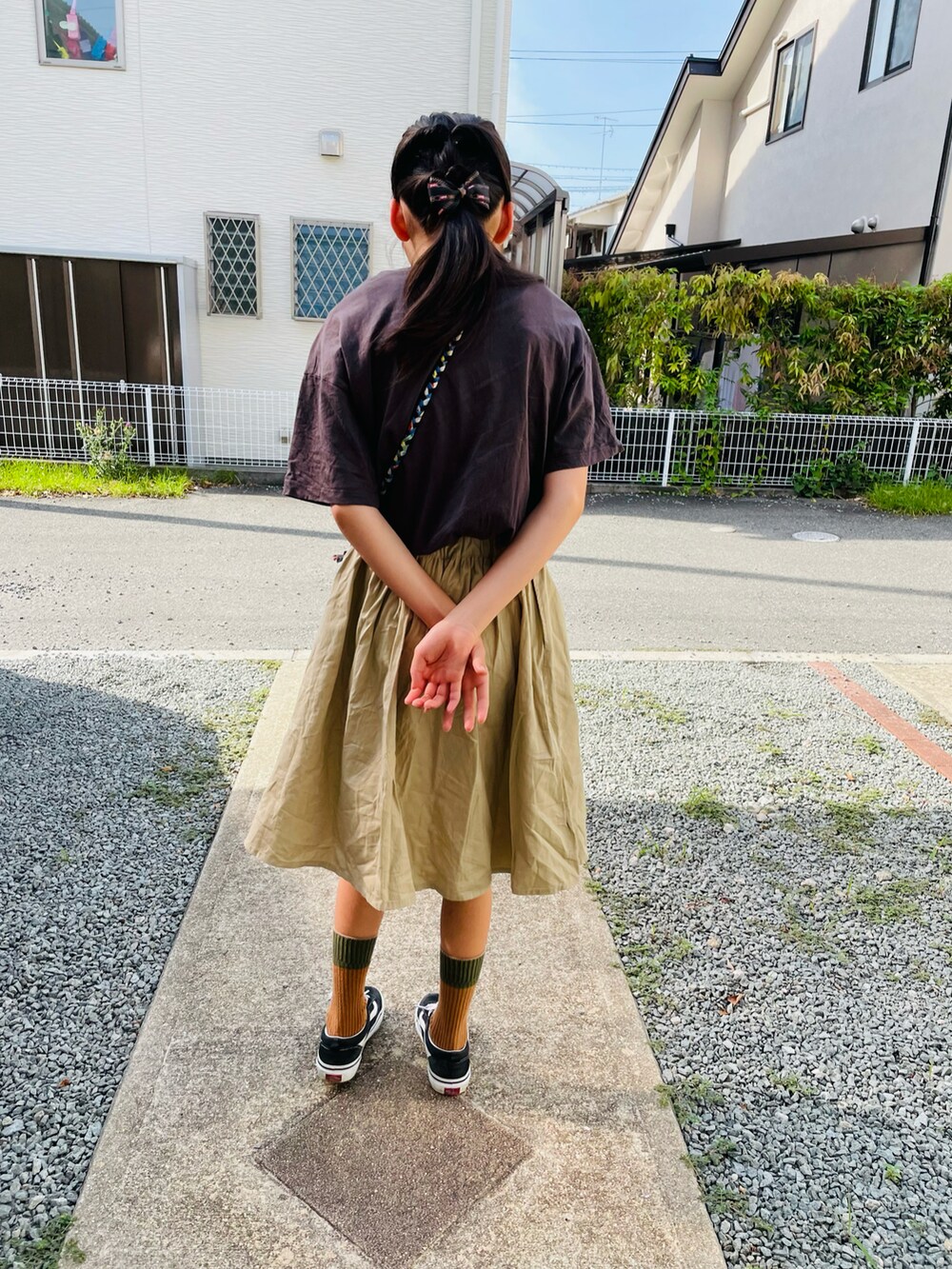 グレー系のTシャツ/カットソー、ベージュ系のスカート、ブラック系のスニーカーを着用したキッズの夏コーディネートの2枚目の写真