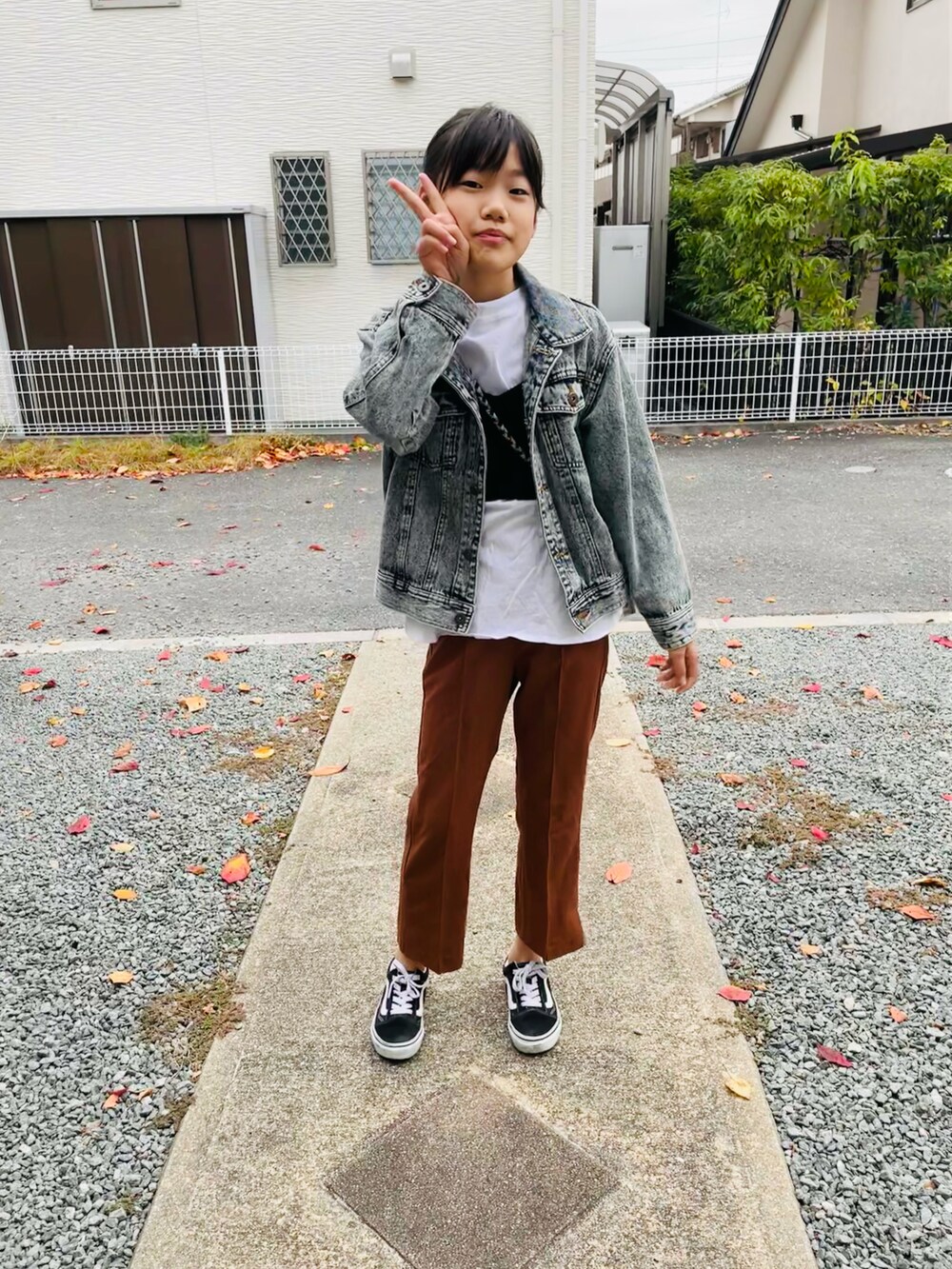 ブルー系のデニムジャケット、ブラウン系のその他パンツ、ブラック系のスニーカーを着用したキッズの秋コーディネートの3枚目の写真