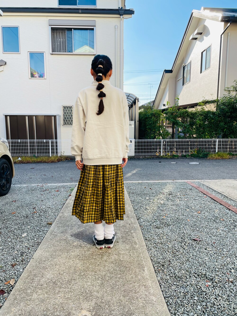 グレー系のスウェット、イエロー系のスカート、ブラック系のスニーカーを着用したキッズの秋コーディネートの4枚目の写真