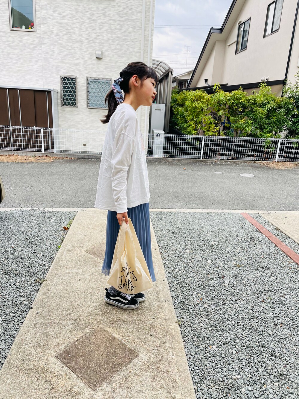 ホワイト系のTシャツ/カットソー、ブルー系のスカート、ホワイト系のエコバッグ/サブバッグを着用したキッズの春コーディネートの3枚目の写真