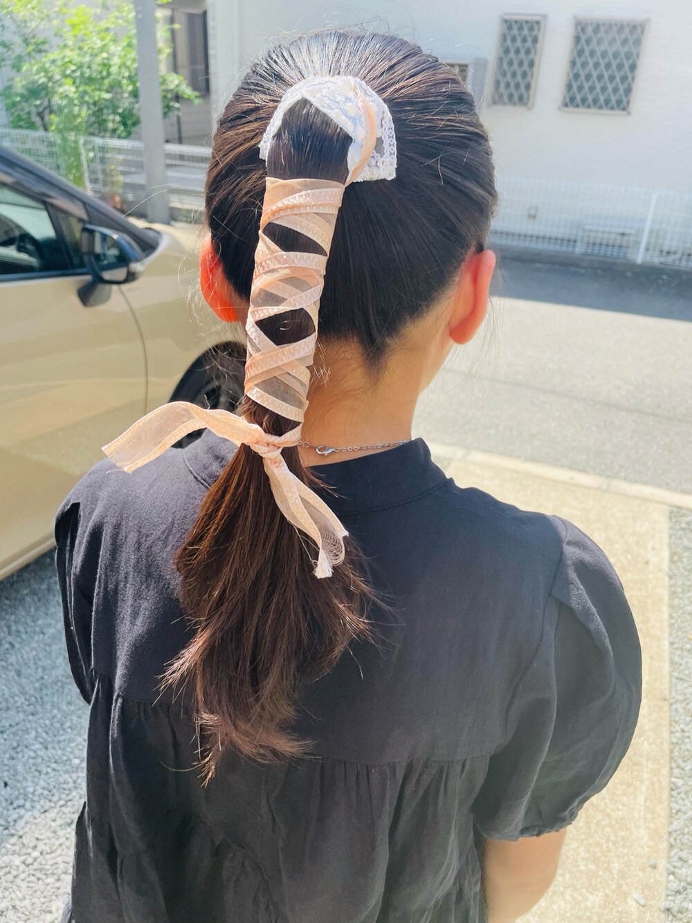 ブラック系のチュニック、ホワイト系のチノパンツ、ブラック系のサンダルを着用したキッズの夏コーディネートの3枚目の写真