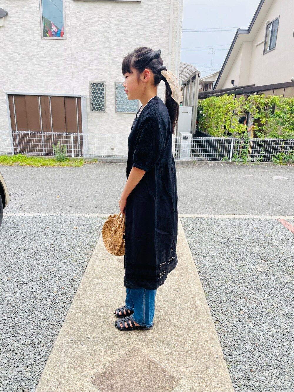 ホワイト系のタンクトップ、ブルー系のサロペット/オーバーオール、ブラック系のサンダルを着用したキッズの夏コーディネートの2枚目の写真