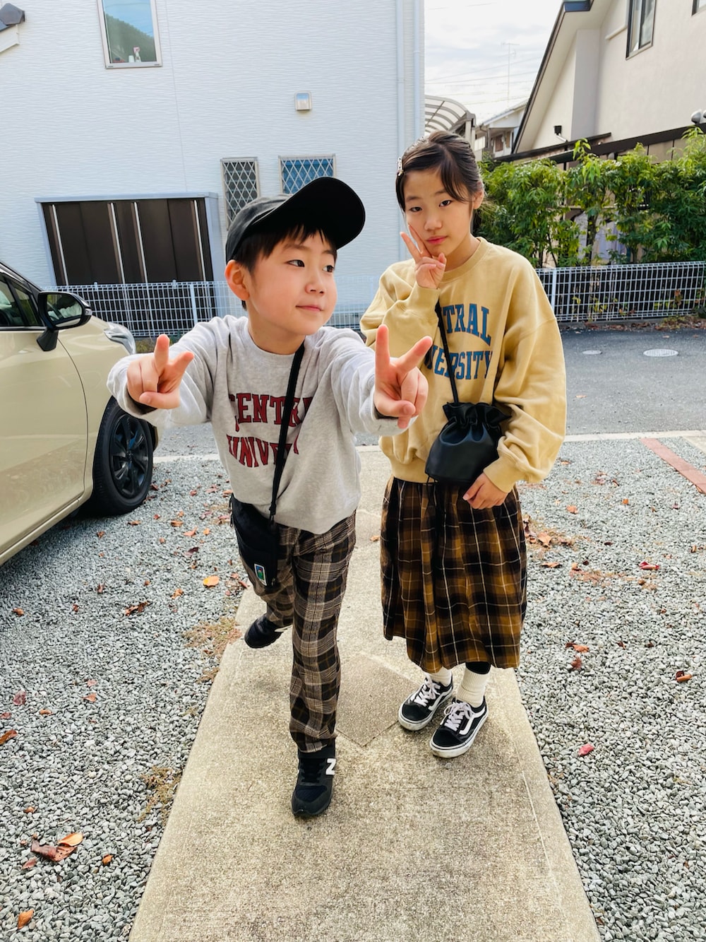 ブラック系のハンドバッグ、ベージュ系のスウェット、グレー系のスウェットを着用したキッズの秋コーディネートの2枚目の写真