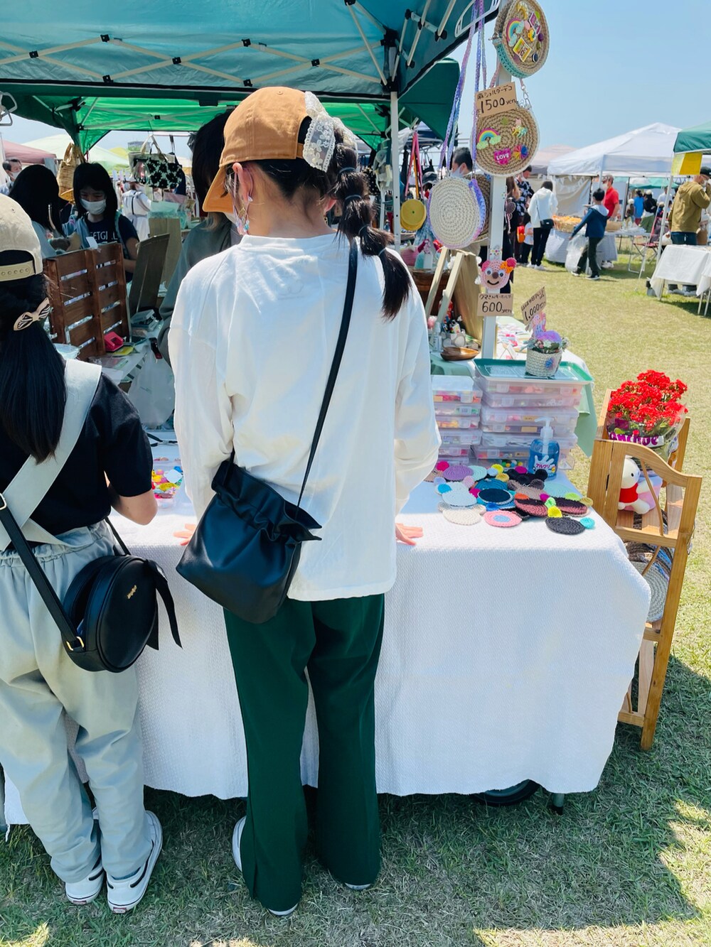 グリーン系のその他パンツ、ホワイト系のTシャツ/カットソー、ブラック系のハンドバッグを着用したキッズの春コーディネートの2枚目の写真