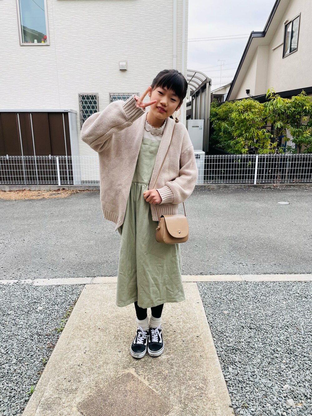 ホワイト系のカーディガン/ボレロ、ベージュ系のショルダーバッグ、グリーン系のワンピースを着用したキッズの春コーディネートの2枚目の写真