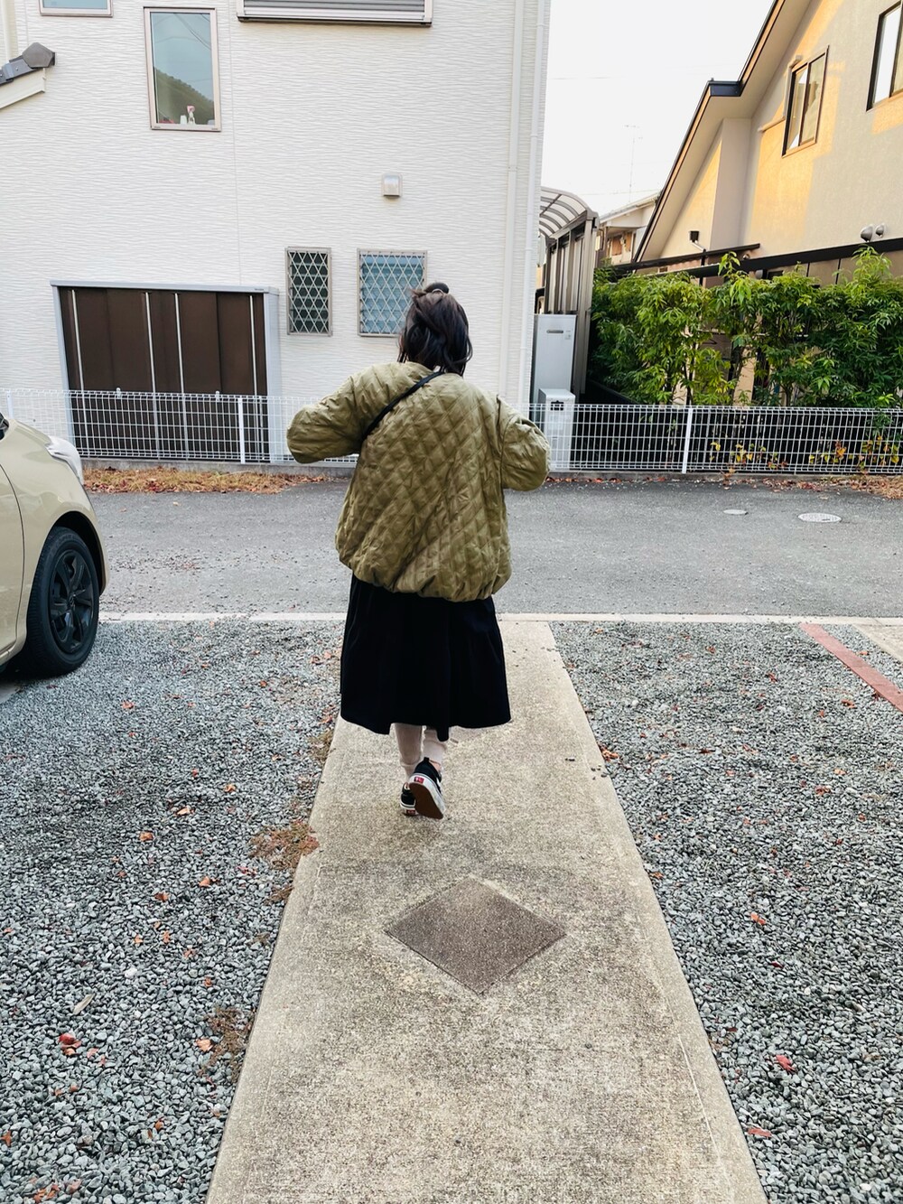 グリーン系のブルゾン、ブラック系のワンピース、ホワイト系のTシャツ/カットソーを着用したキッズの冬コーディネートの3枚目の写真