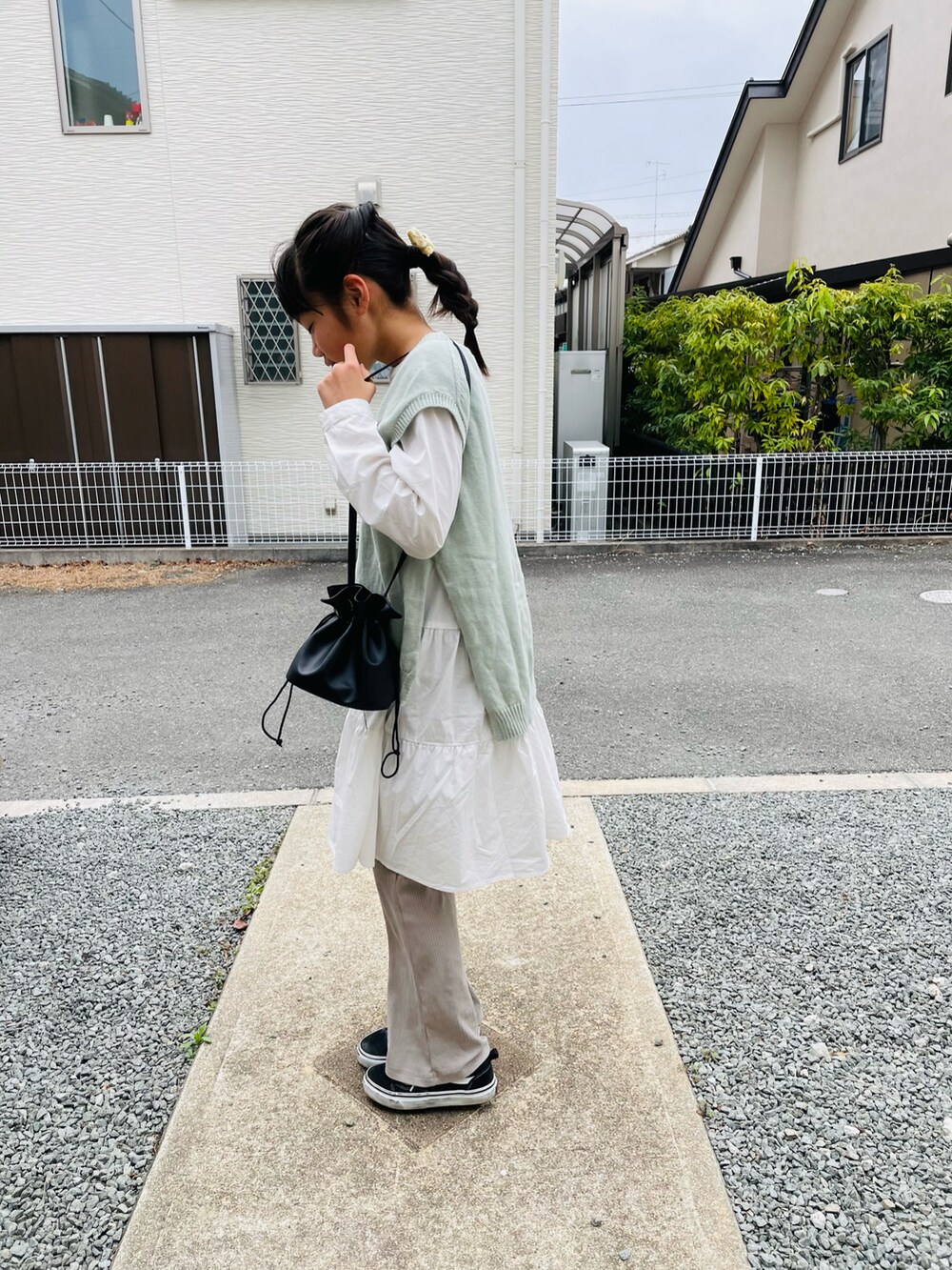 ブラック系のハンドバッグ、グリーン系のワンピース、ホワイト系のワンピースを着用したキッズの春コーディネートの3枚目の写真