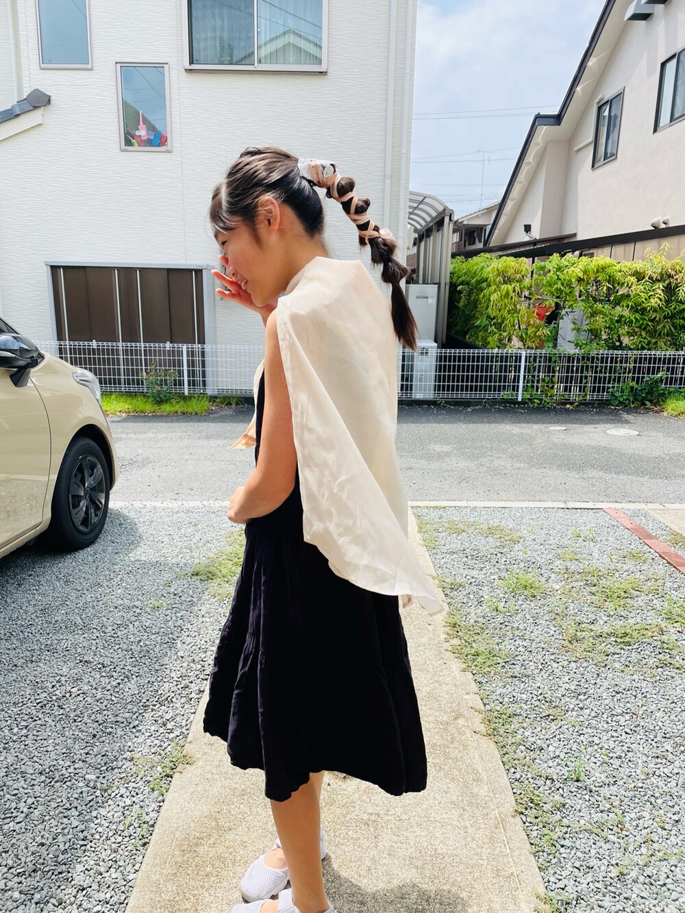 ブラック系のバッグ、ブラック系のワンピース、ホワイト系のスニーカーを着用したキッズの夏コーディネートの2枚目の写真