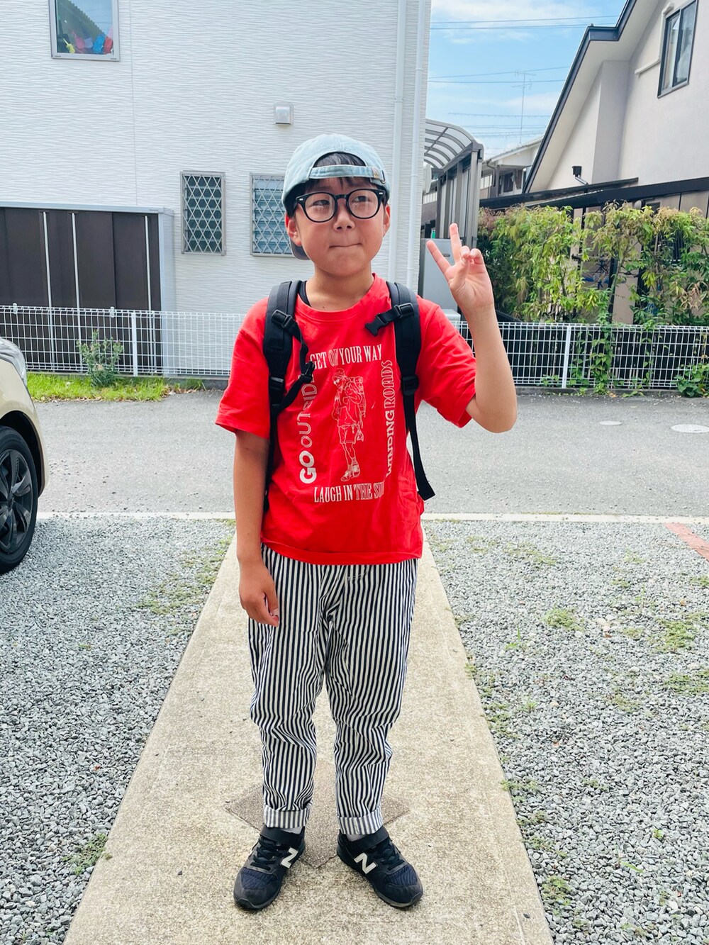 レッド系のTシャツ/カットソー、ホワイト系のその他パンツ、ブラック系のスニーカーを着用したキッズの夏コーディネートの3枚目の写真