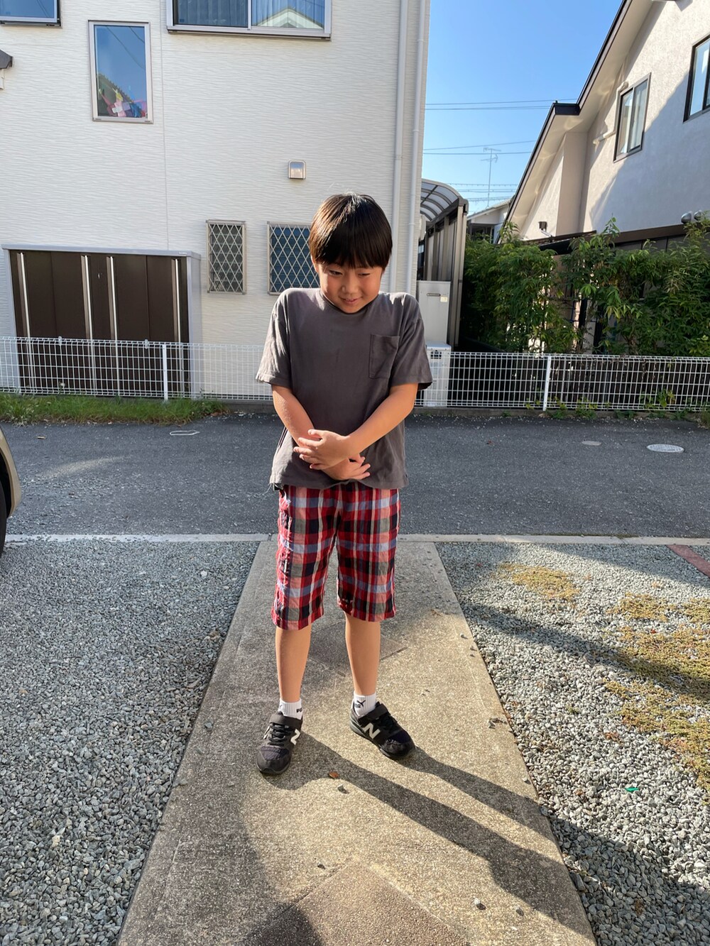 グレー系のTシャツ/カットソー、レッド系のその他パンツ、ブラック系のスニーカーを着用したキッズの秋コーディネートの2枚目の写真