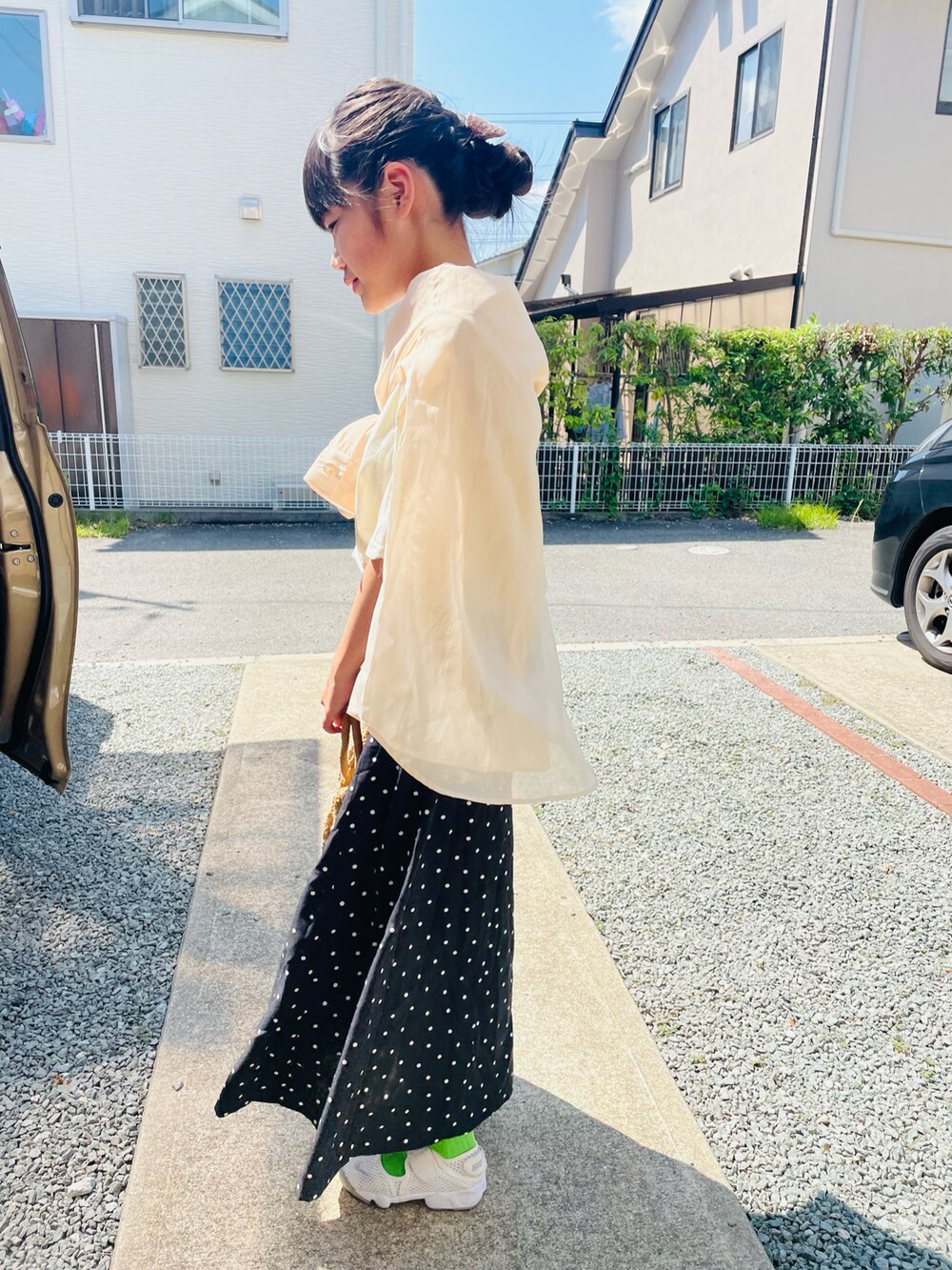 ホワイト系のTシャツ/カットソー、ブラック系のスカート、ホワイト系のスニーカーを着用したキッズの夏コーディネートの2枚目の写真