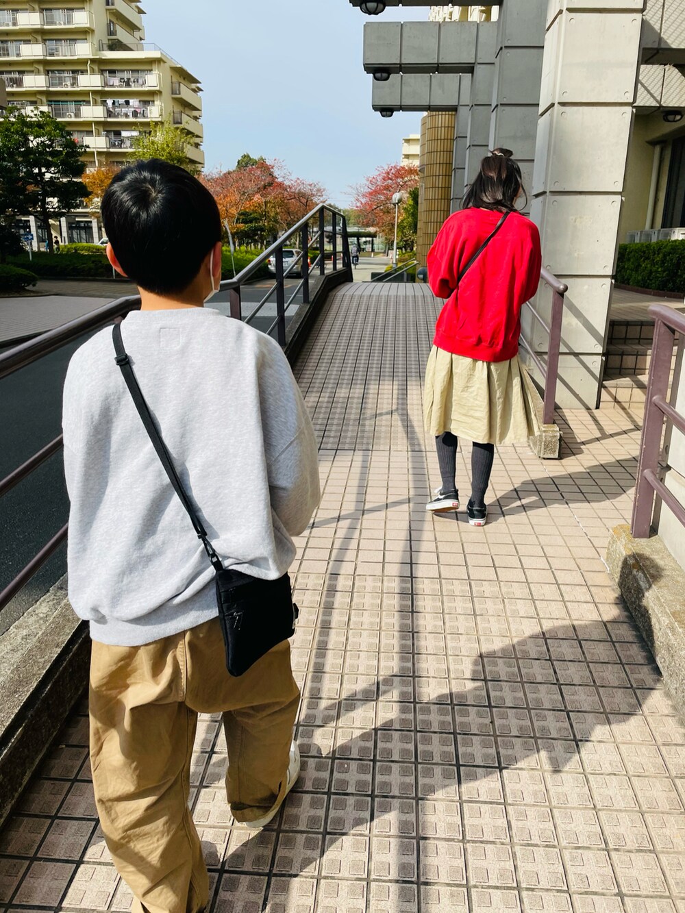 ベージュ系のスカート、グレー系のスウェット、ベージュ系のその他パンツを着用したキッズの秋コーディネートの3枚目の写真