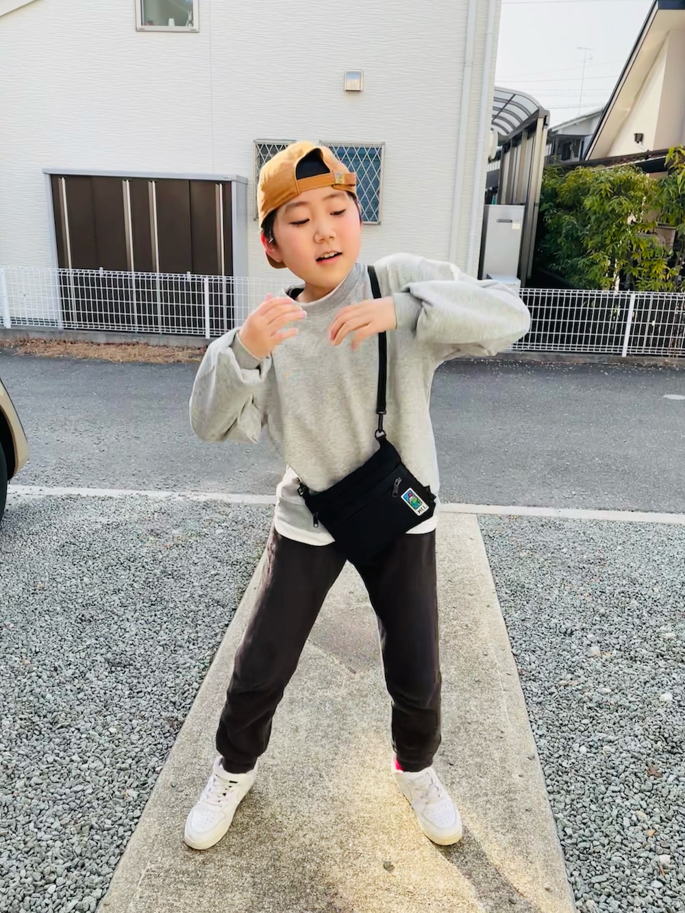 グレー系のTシャツ/カットソー、ブラック系のショルダーバッグ、グレー系のその他パンツを着用したキッズの春コーディネートの3枚目の写真