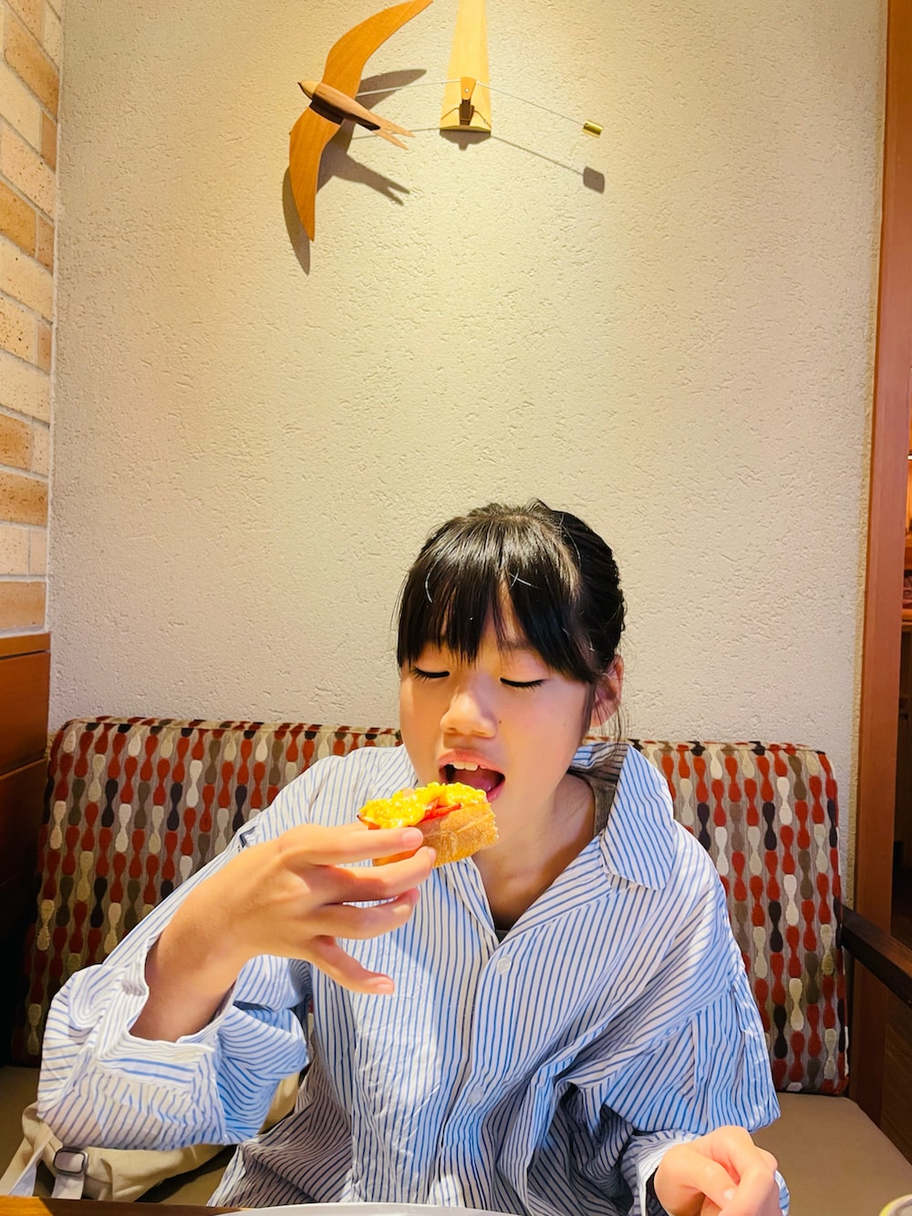 ブラック系のショルダーバッグ、ブルー系のシャツワンピース、ブルー系のデニムパンツを着用したキッズの秋コーディネートの4枚目の写真