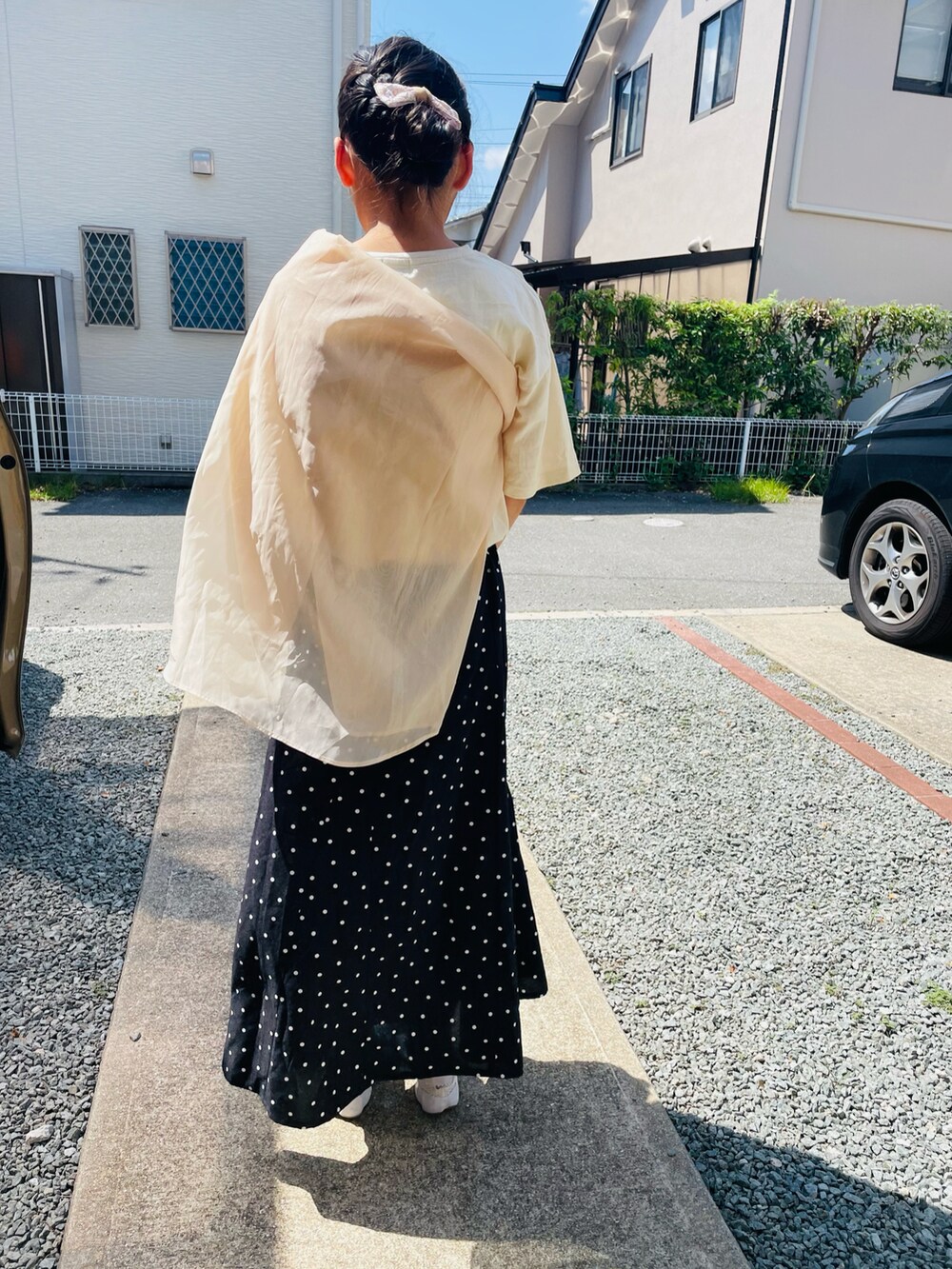 ホワイト系のTシャツ/カットソー、ブラック系のスカート、ホワイト系のスニーカーを着用したキッズの夏コーディネートの3枚目の写真