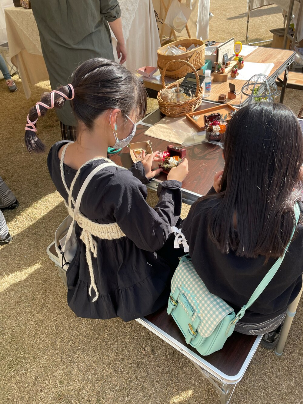 ブラック系のワンピース、ホワイト系のトップス、ベージュ系のスニーカーを着用したキッズの秋コーディネートの4枚目の写真