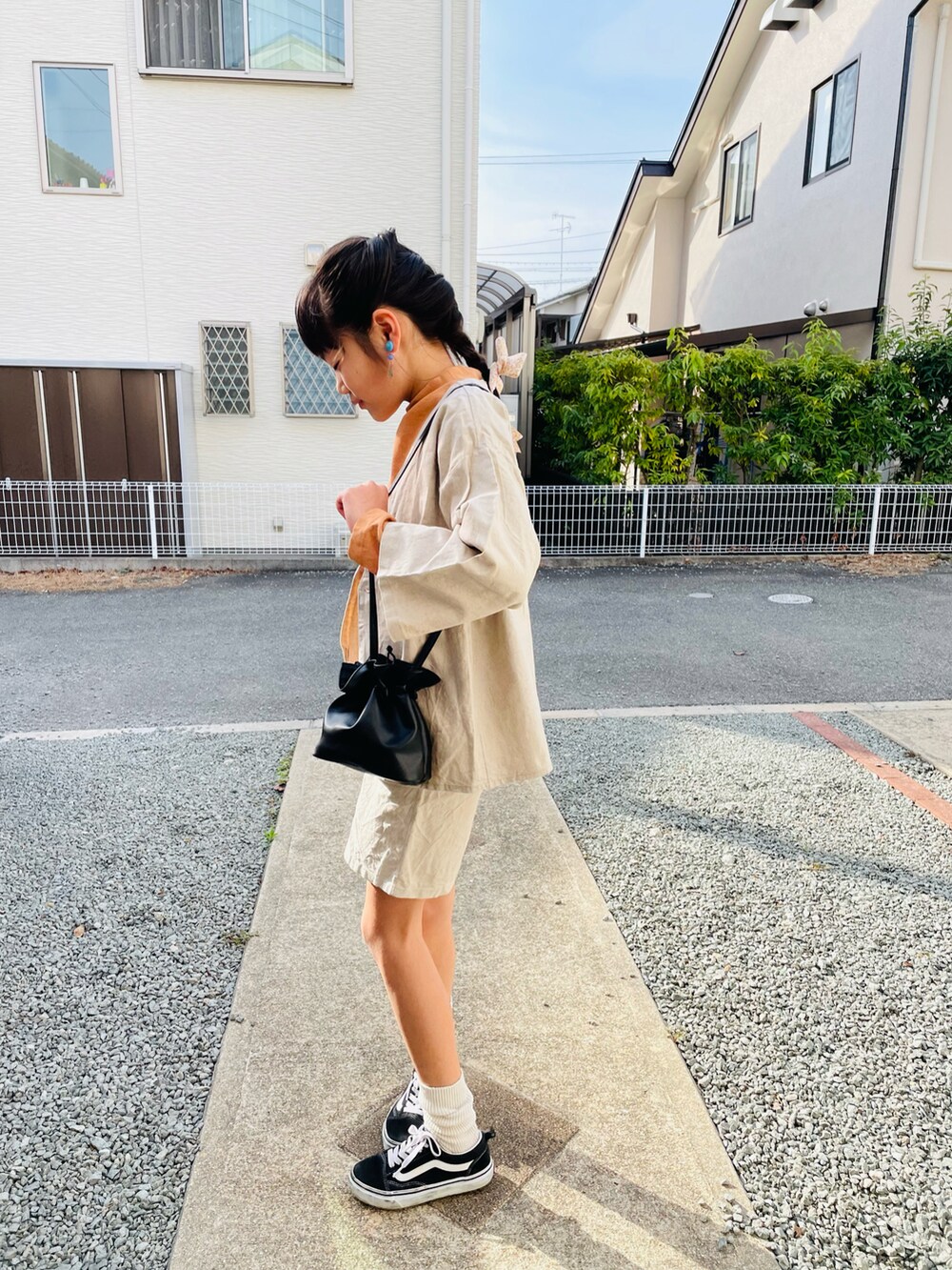 ベージュ系のジャケット/アウター、オレンジ系のTシャツ/カットソー、ブラック系のハンドバッグを着用したキッズの春コーディネートの2枚目の写真