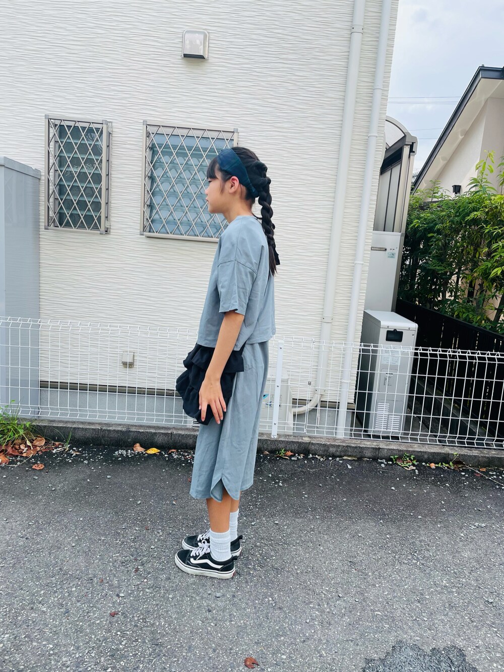 グリーン系のワンピース、ブラック系のスニーカーを着用したキッズの秋コーディネートの2枚目の写真