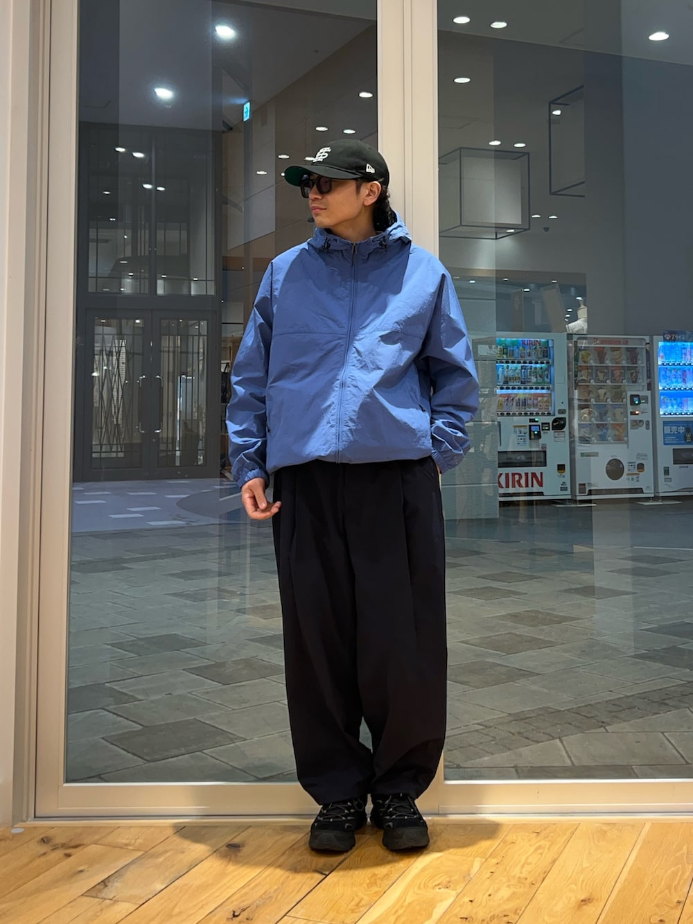 ブルー系のナイロンジャケット、ブルー系のその他パンツ、ホワイト系のTシャツ/カットソーを着用したメンズの春コーディネートの4枚目の写真