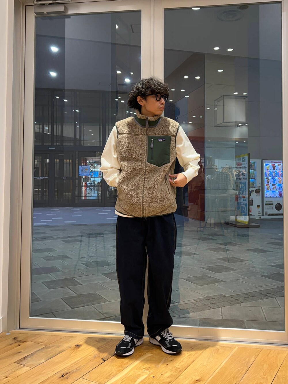 ブルー系のデニムパンツ、ホワイト系のスウェット、ベージュ系のテーラードジャケットを着用したメンズの秋コーディネートの2枚目の写真