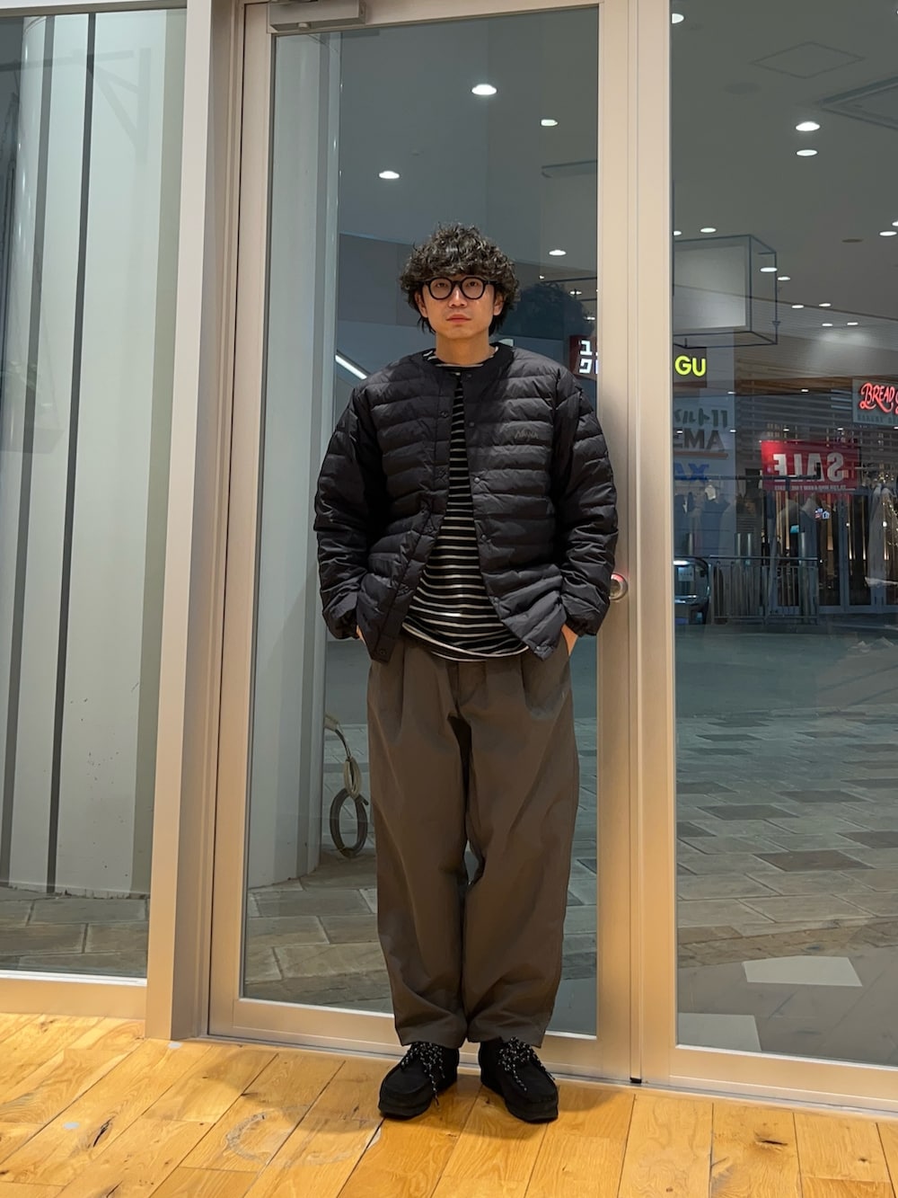 グレー系のその他パンツ、グレー系のTシャツ/カットソー、ブラック系のダウンジャケット/コートを着用したメンズの冬コーディネートの3枚目の写真