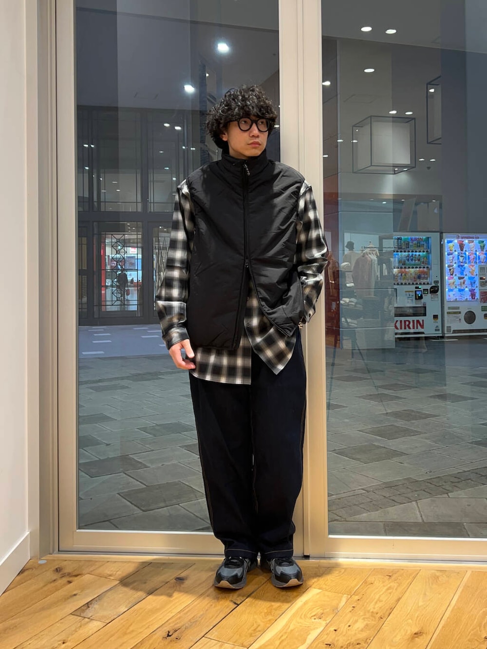 ブラック系のシャツ/ブラウス、ブラック系のダウンベスト、ブルー系のデニムパンツを着用したメンズの冬コーディネートの2枚目の写真