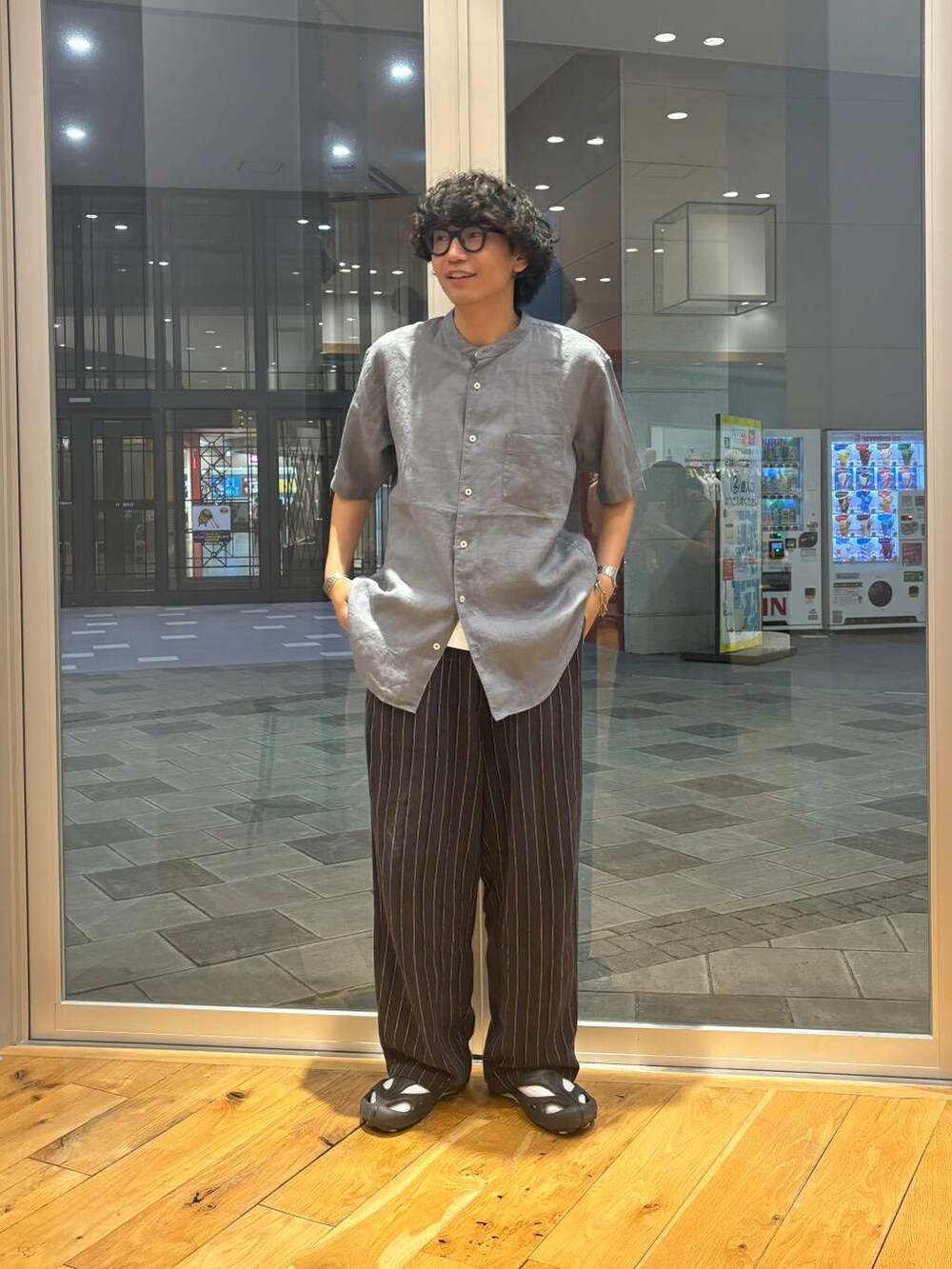 ブルー系のシャツ/ブラウス、ブラック系のサンダルを着用したメンズの夏コーディネートの2枚目の写真