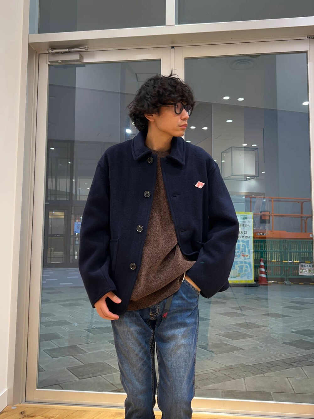 ブルー系のデニムパンツ、ブラウン系のニット/セーター、ブルー系のカバーオールを着用したメンズの冬コーディネートの2枚目の写真