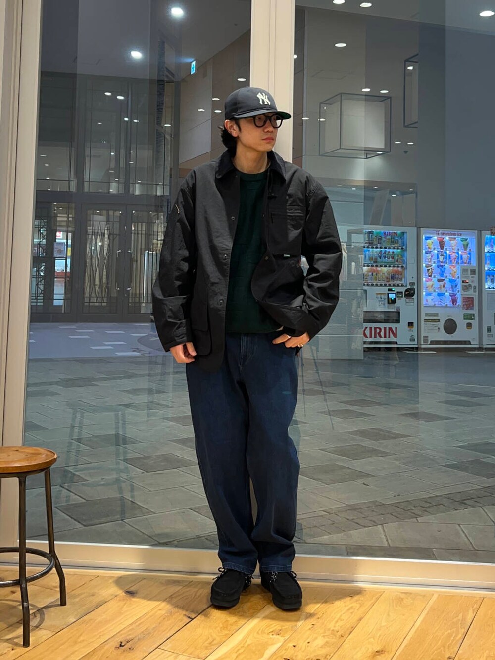 グリーン系のニット/セーター、ブルー系のデニムパンツ、グレー系のテーラードジャケットを着用したメンズの冬コーディネートの2枚目の写真