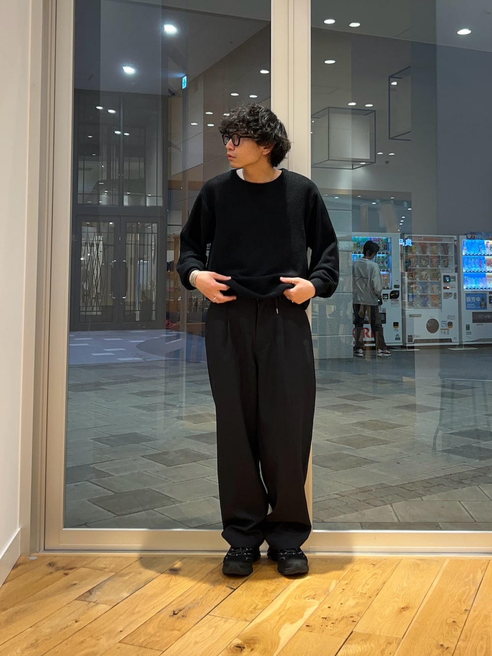 ブラック系のニット/セーター、ブルー系のその他パンツを着用したメンズの春コーディネートの2枚目の写真