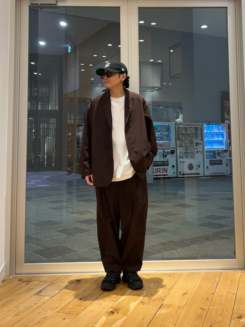 ブラウン系のその他アウター、ブラウン系のその他パンツ、ホワイト系のTシャツ/カットソーを着用したメンズの春コーディネートの2枚目の写真