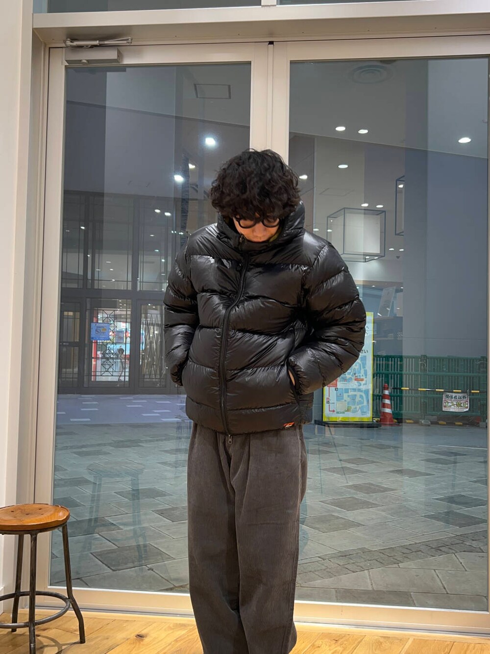 グレー系のスニーカー、グリーン系のその他パンツ、ブラック系のダウンジャケット/コートを着用したメンズの冬コーディネートの2枚目の写真