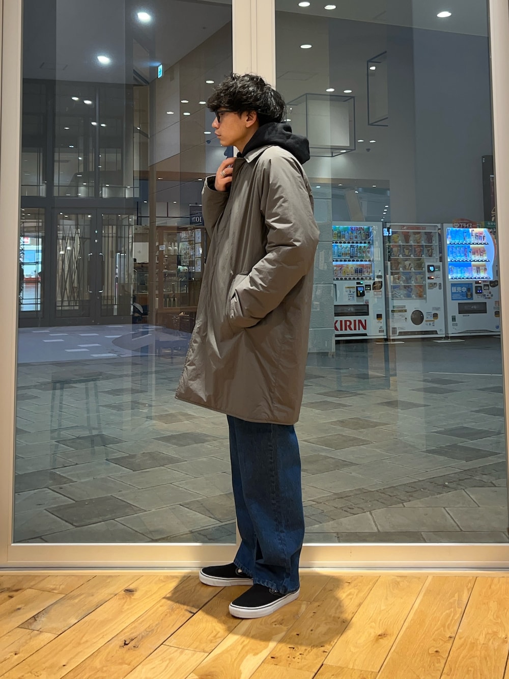 グレー系のその他アウター、ブラック系のパーカー、ブルー系のデニムパンツを着用したメンズの冬コーディネートの2枚目の写真