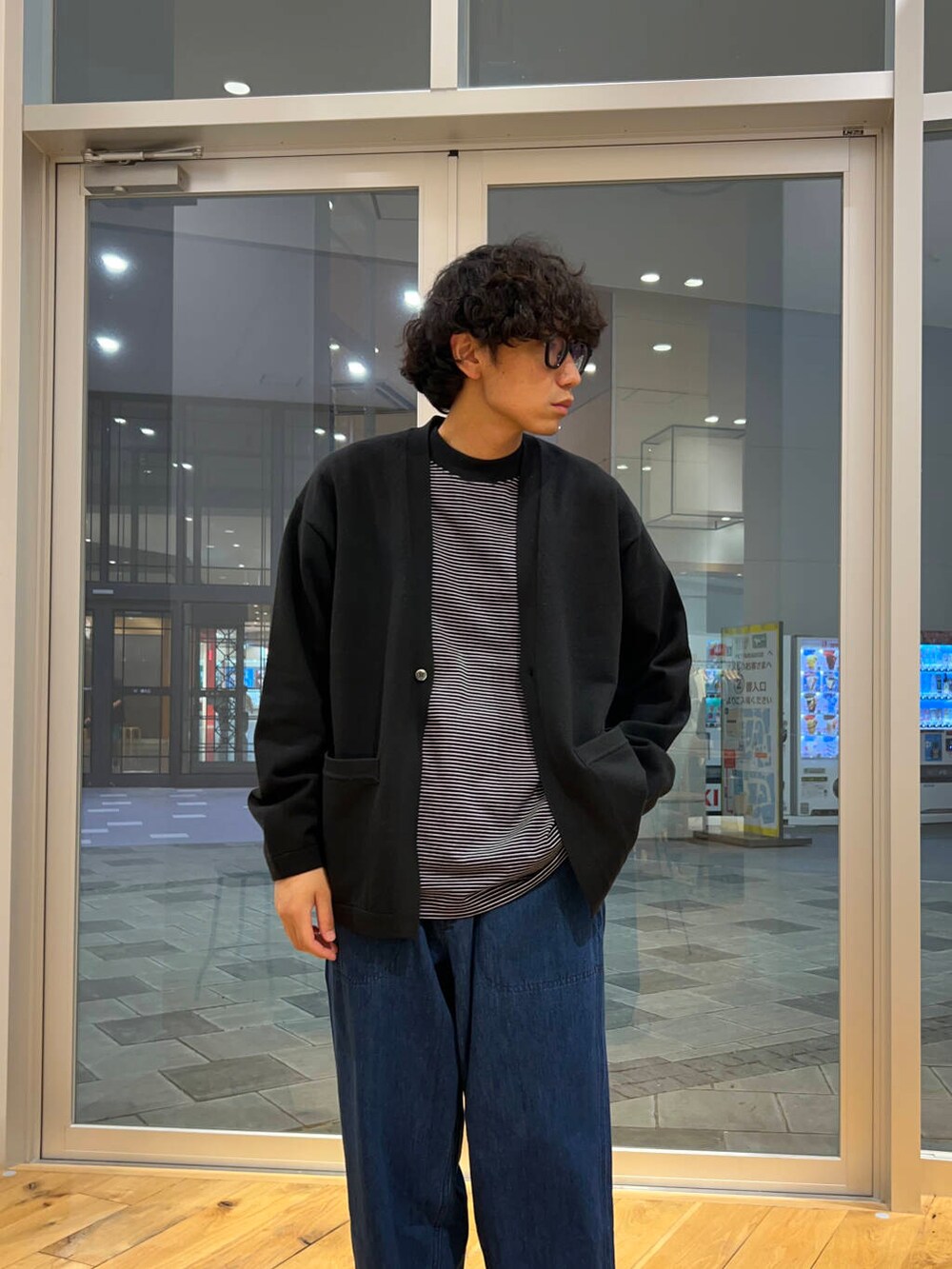 ベージュ系のスニーカー、ブルー系のデニムパンツ、ブラック系のTシャツ/カットソーを着用したメンズの秋コーディネートの3枚目の写真