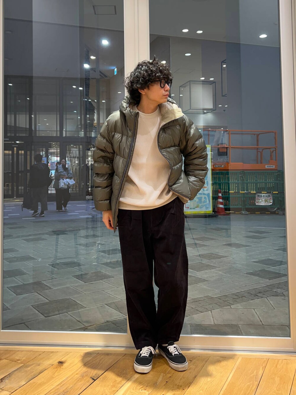 グレー系のその他パンツ、ベージュ系のTシャツ/カットソー、グリーン系のダウンジャケット/コートを着用したメンズの秋コーディネートの2枚目の写真