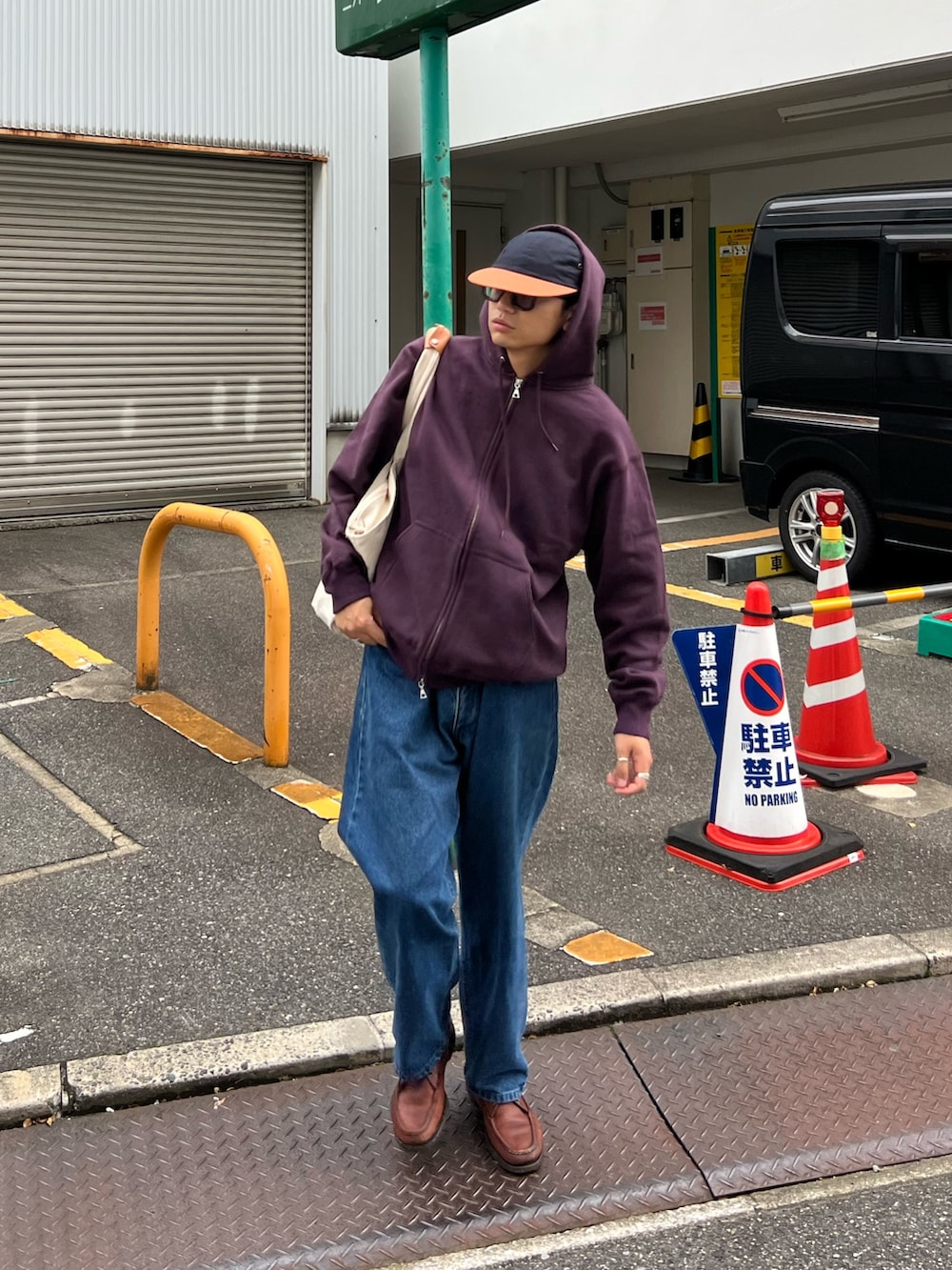 パープル系のパーカー、ブルー系のデニムパンツを着用したメンズの秋コーディネートの3枚目の写真