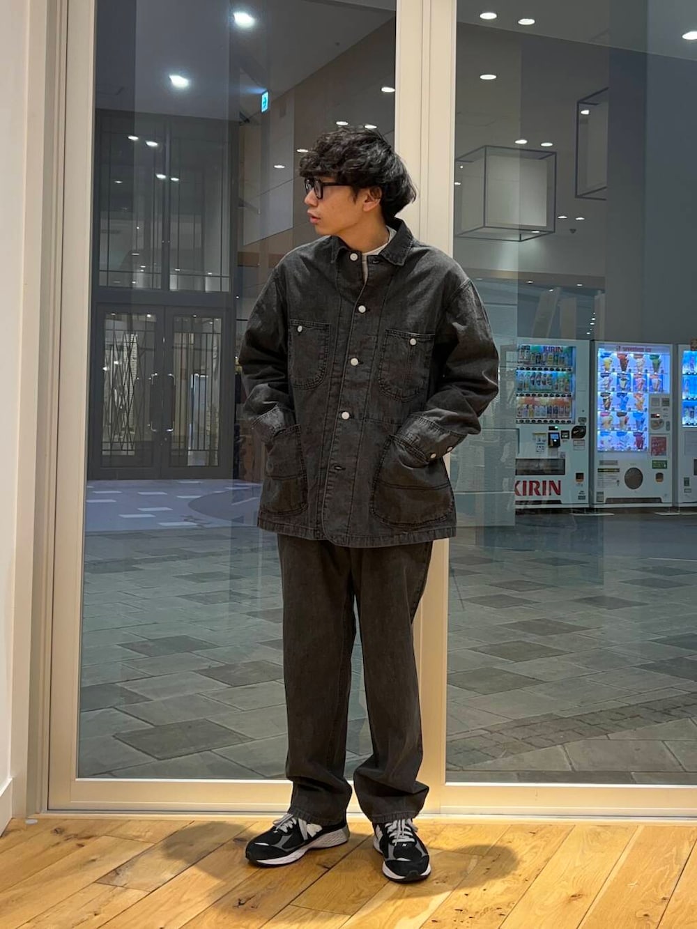 ブラック系のデニムパンツ、ブラック系のカバーオール、グレー系のTシャツ/カットソーを着用したメンズの春コーディネートの3枚目の写真