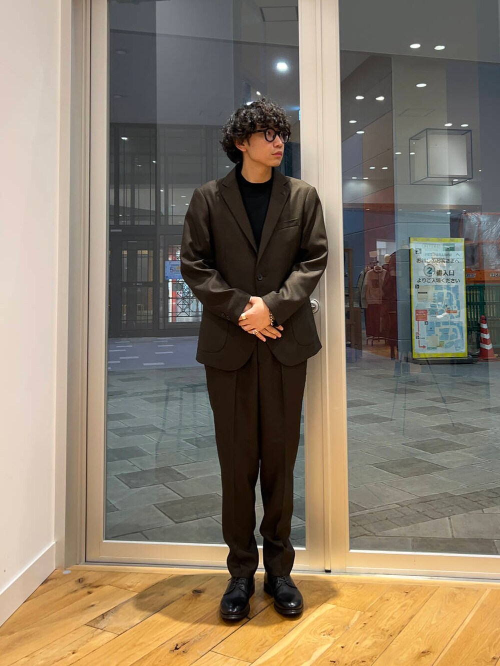 ブラック系のドレスシューズ、ブラック系のシャツ/ブラウス、ブラウン系のスーツパンツを着用したメンズの秋コーディネートの2枚目の写真