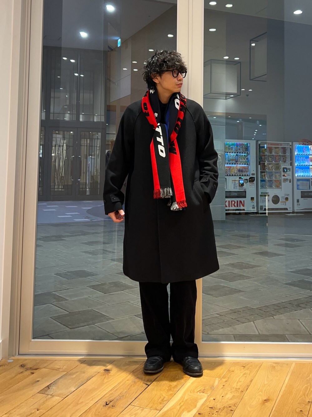 ブラック系のステンカラーコート、グレー系のその他パンツ、ブラック系のニット/セーターを着用したメンズの秋コーディネートの6枚目の写真