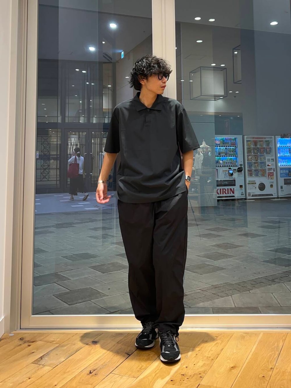 グレー系のポロシャツ、ブラック系のその他パンツを着用したメンズの夏コーディネートの2枚目の写真