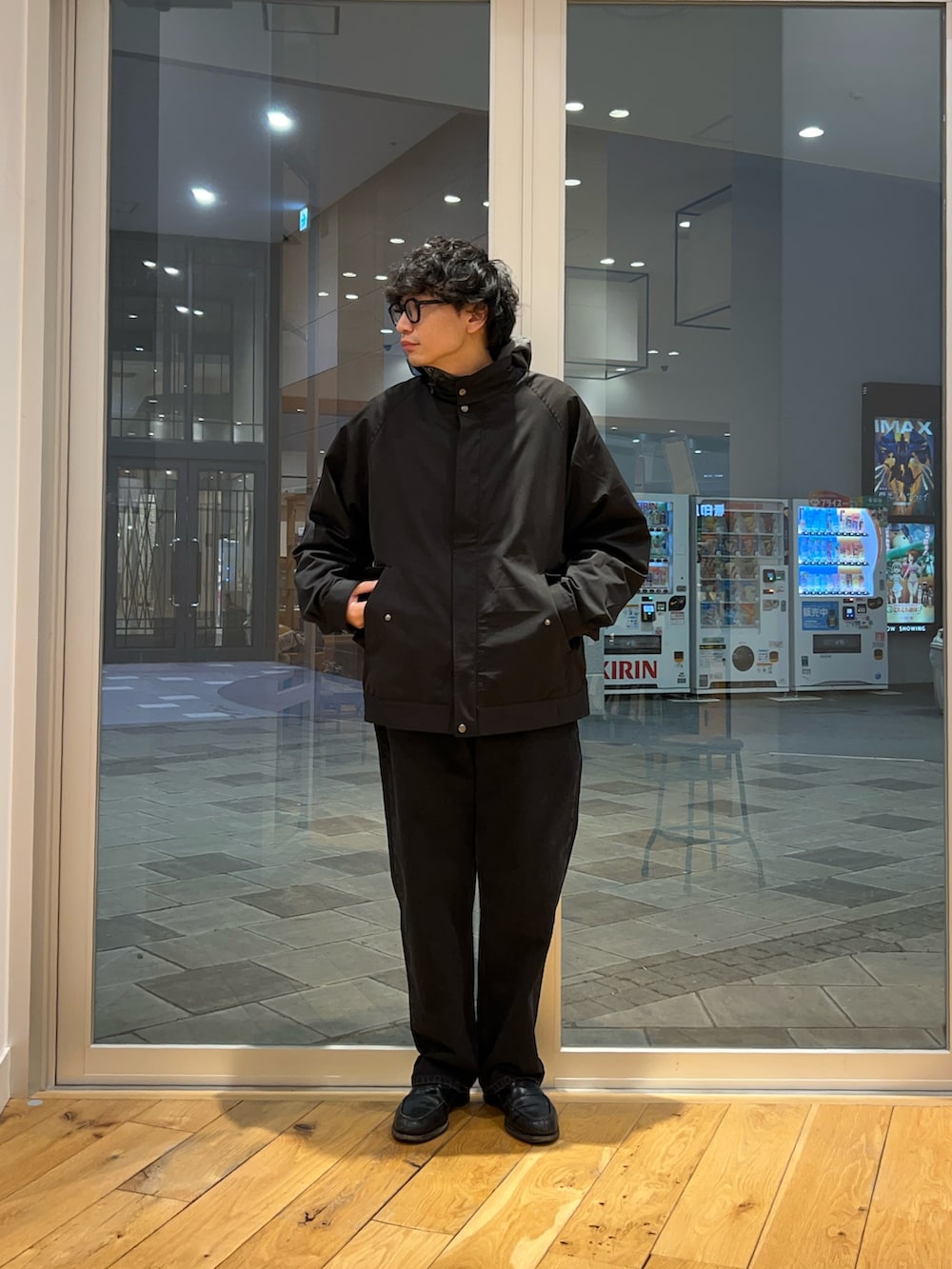 ブラック系のブルゾン、グレー系のナイロンジャケット、ブラック系のデニムパンツを着用したメンズの冬コーディネートの2枚目の写真