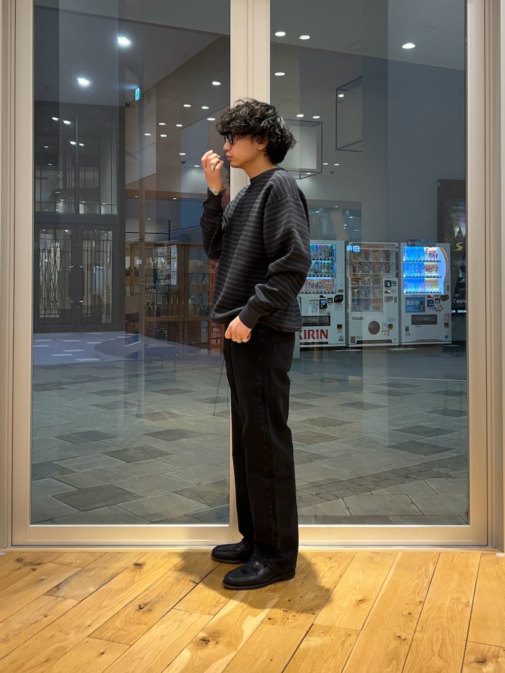 グレー系のニット/セーター、ブラック系のデニムパンツを着用したメンズの春コーディネートの2枚目の写真