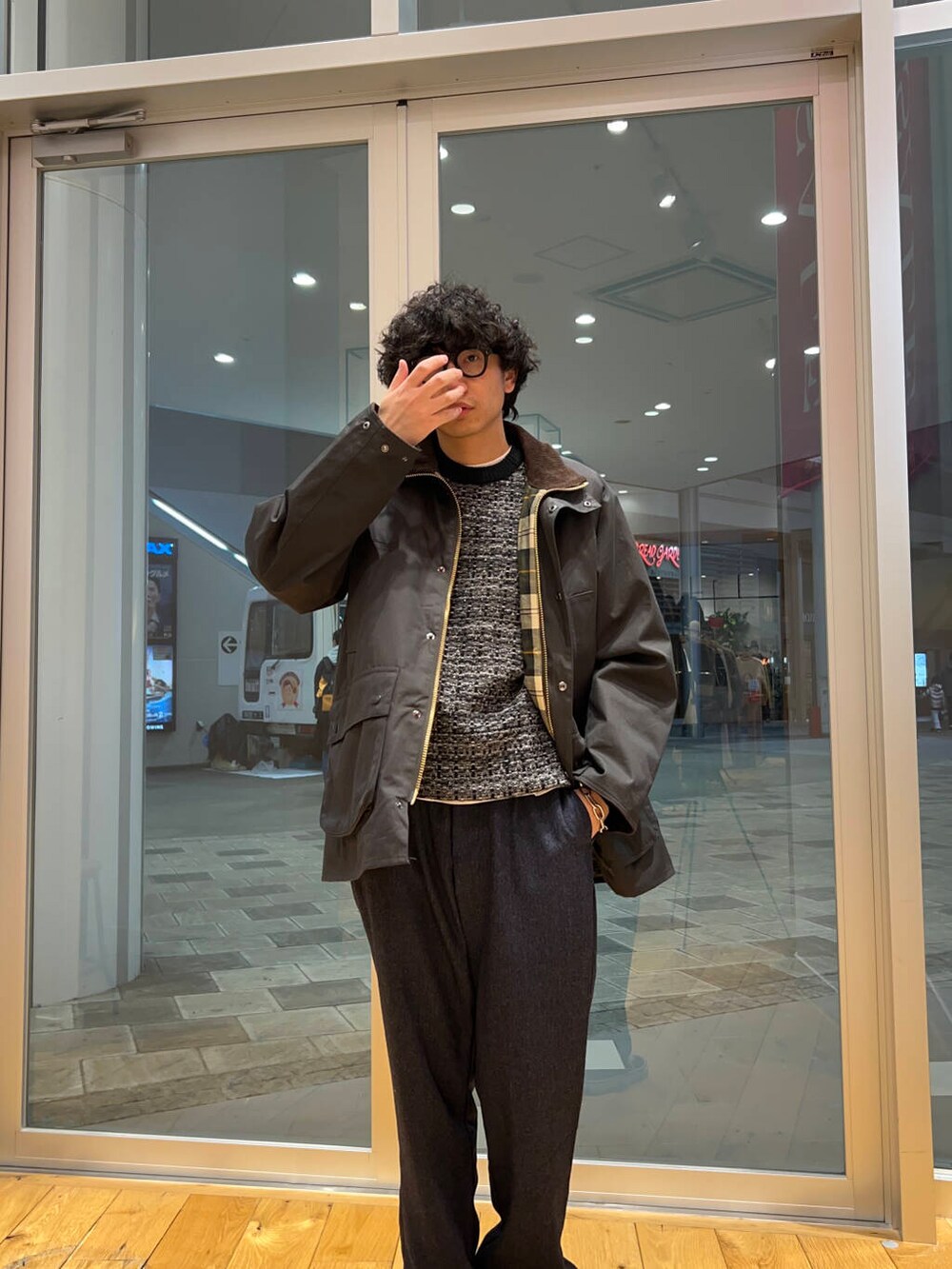 グリーン系のその他アウター、ブルー系のその他パンツ、ブラック系のニット/セーターを着用したメンズの冬コーディネートの2枚目の写真