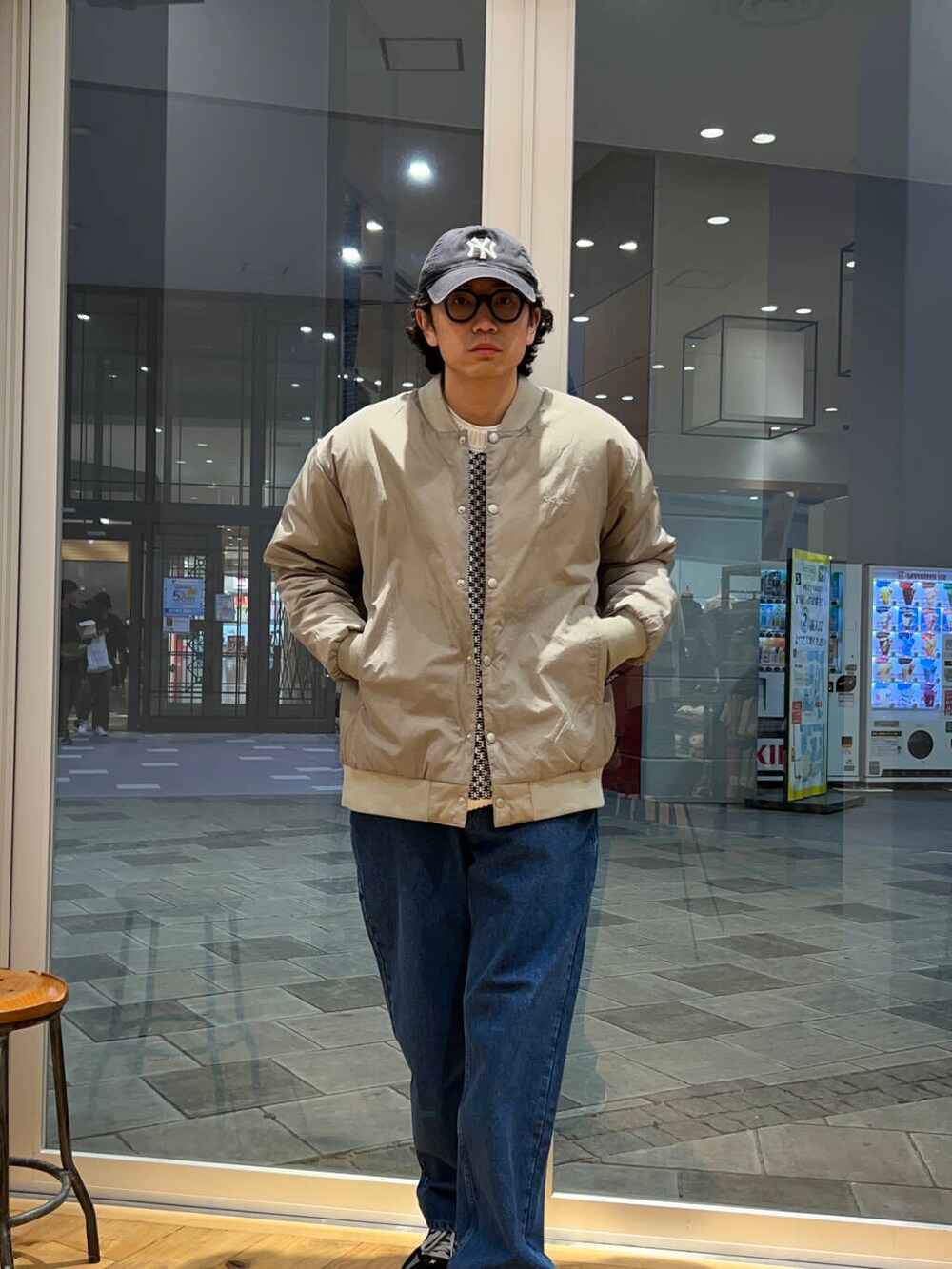 ブルー系のデニムパンツ、ホワイト系のニット/セーター、グレー系のダウンジャケット/コートを着用したメンズの冬コーディネートの2枚目の写真