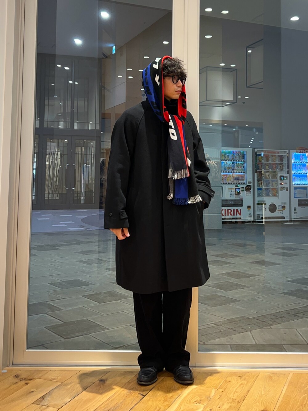 ブラック系のステンカラーコート、グレー系のその他パンツ、ブラック系のニット/セーターを着用したメンズの秋コーディネートの2枚目の写真
