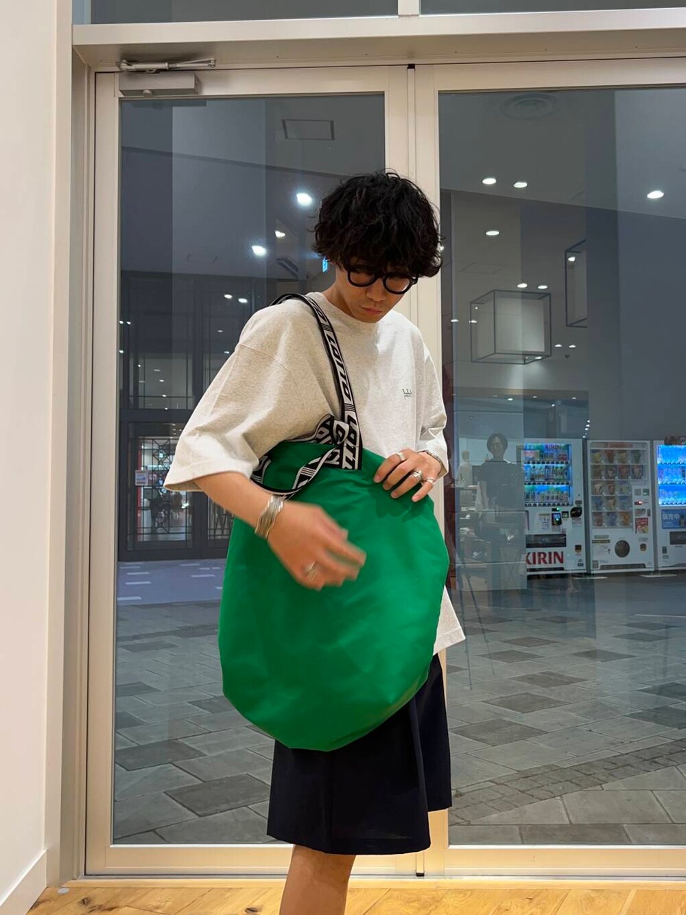 ブルー系のその他パンツ、グリーン系のトートバッグを着用したメンズの夏コーディネートの3枚目の写真