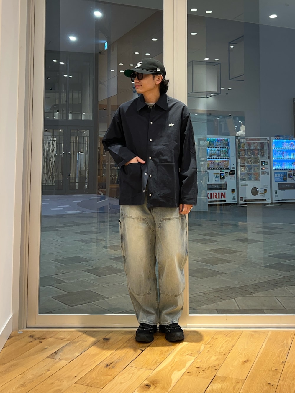 ブルー系のデニムパンツ、グレー系のニット/セーターを着用したメンズの春コーディネートの2枚目の写真