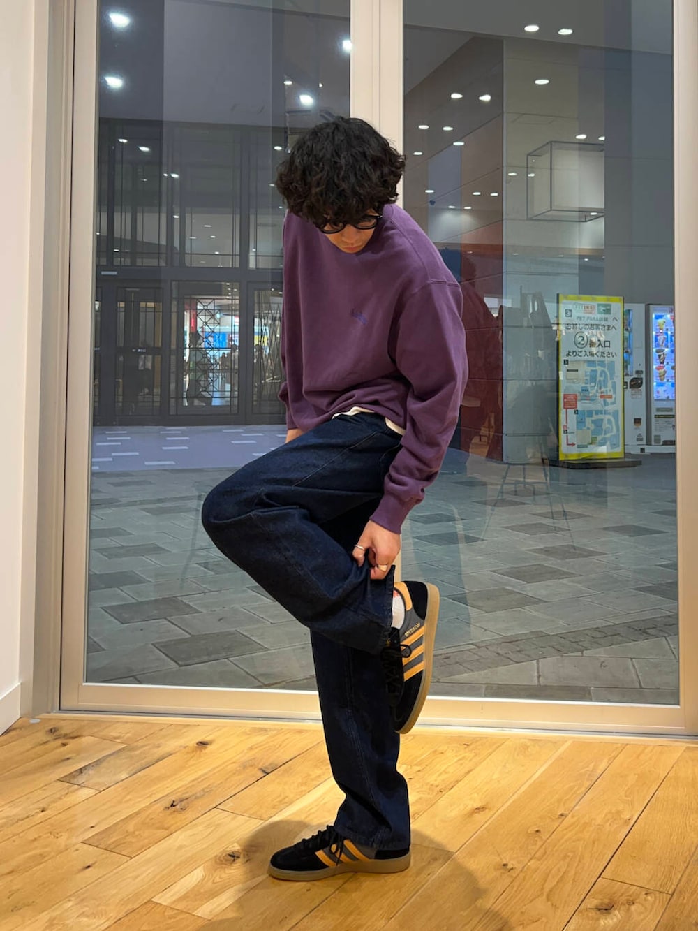 ブルー系のデニムパンツ、ブラック系のスニーカー、パープル系のスウェットを着用したメンズの秋コーディネートの2枚目の写真