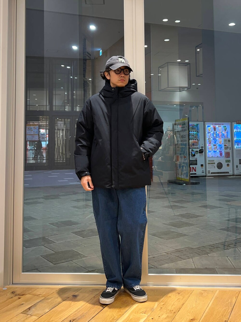 ブルー系のデニムパンツ、グレー系のニット/セーター、ブルー系のダウンジャケット/コートを着用したメンズの冬コーディネートの2枚目の写真