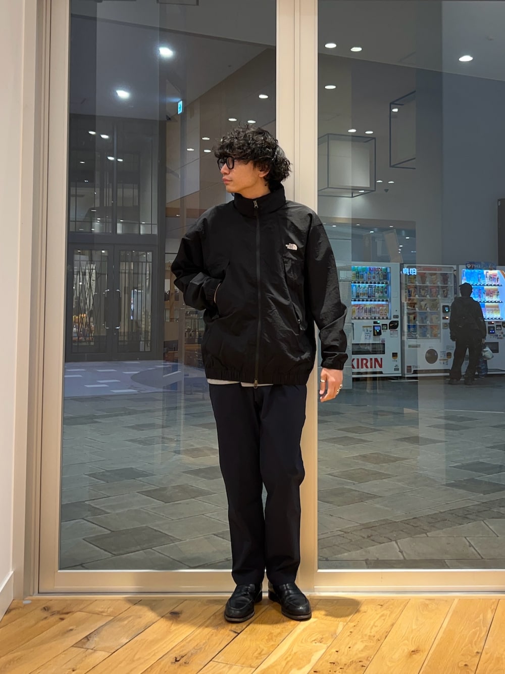 ブラック系のブルゾン、ブルー系のその他パンツ、グレー系のTシャツ/カットソーを着用したメンズの春コーディネートの2枚目の写真